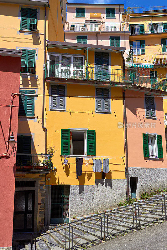 在意大利Riomaggiore街道上，一幢老房子的窗户上挂着洗好的衣服