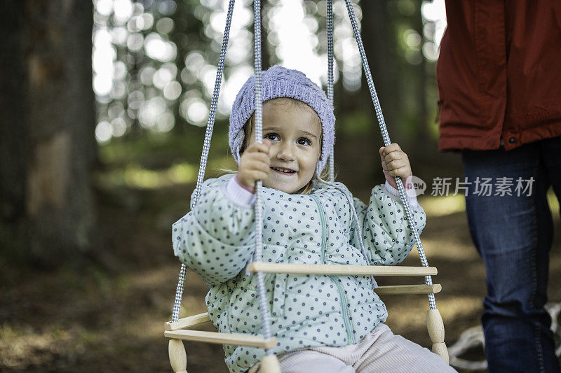 妈妈和孩子在森林里玩滑索。家庭露营。本空间