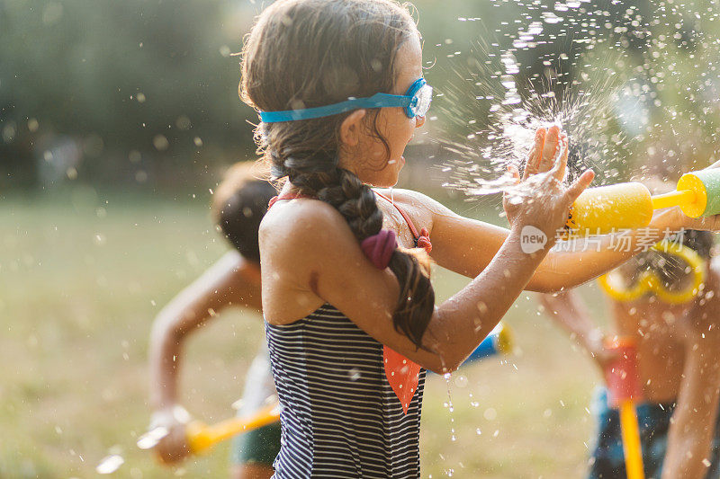 炎热的夏日，孩子们在院子里打水仗