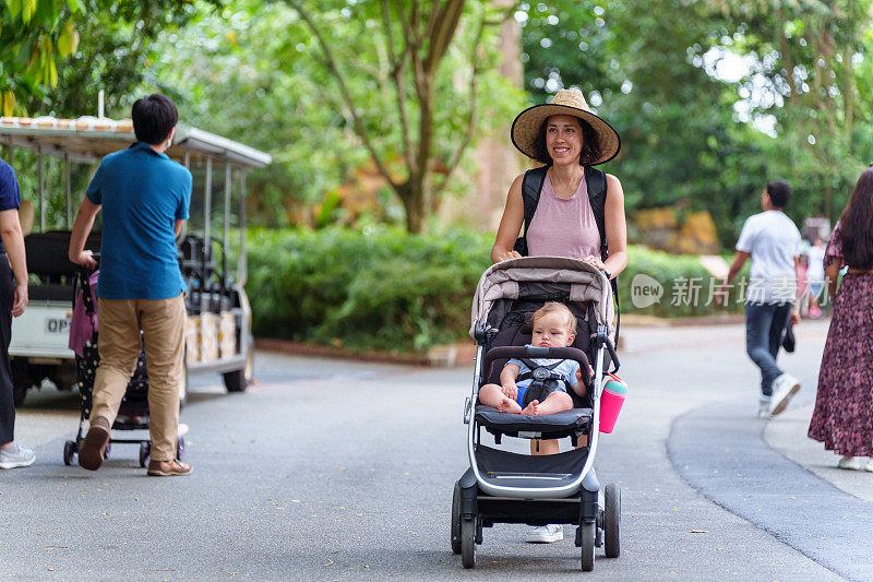 新加坡，一名欧亚妇女推着婴儿车穿过繁忙的植物园