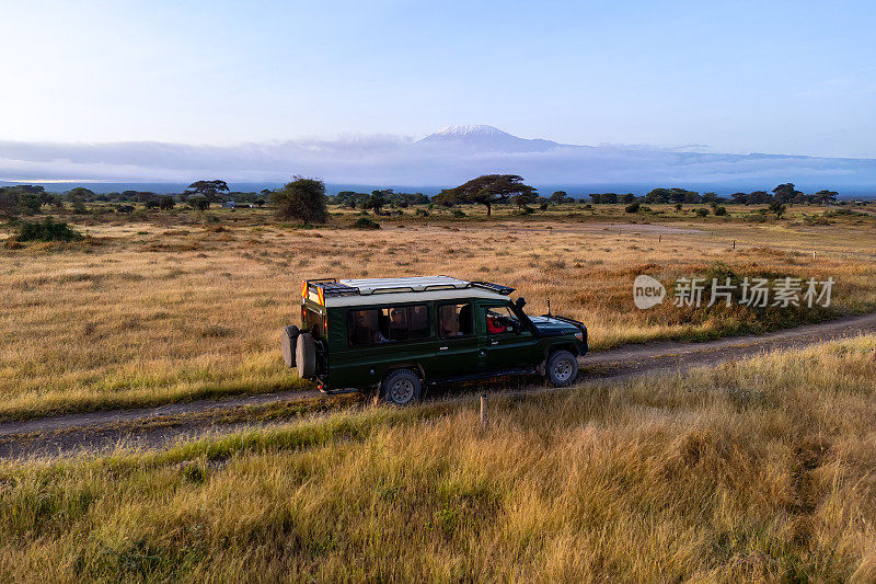 安博塞利国家公园，肯尼亚。午后，敞篷越野车正行驶在大草原上。非洲，肯尼亚，野生动物保护区，与角马一起狩猎