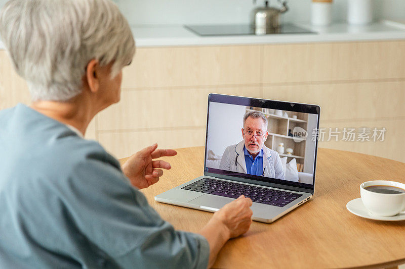 老年男子医生专家检查老年妇女在线。老妇人、病人和医生通过视频通话，用笔记本电脑进行会诊。医药保健体检。在线医生。