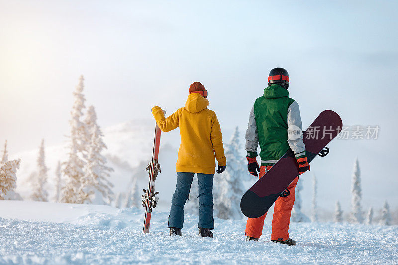 滑雪者和单板滑雪者站在滑雪场的背景上