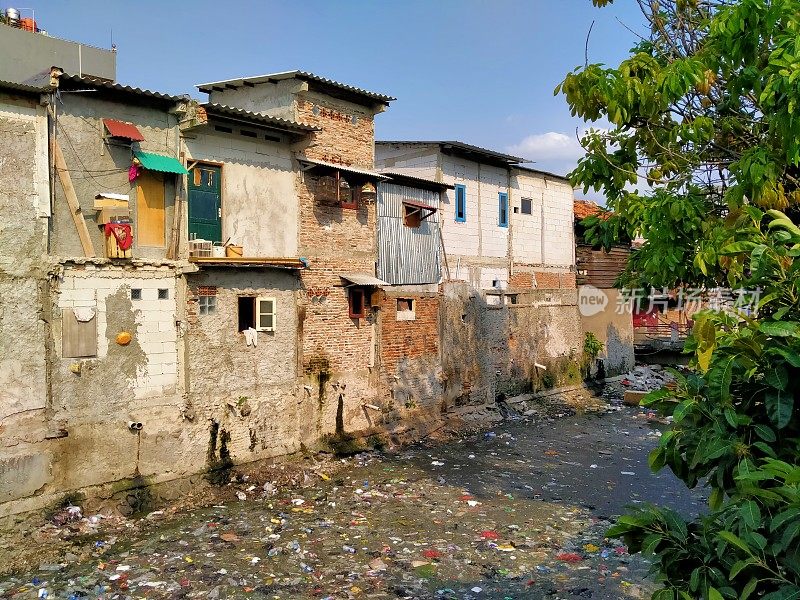 印度尼西亚雅加达坦博拉市-(04-25-2021):河边一座肮脏恶臭的贫民窟建筑的气氛