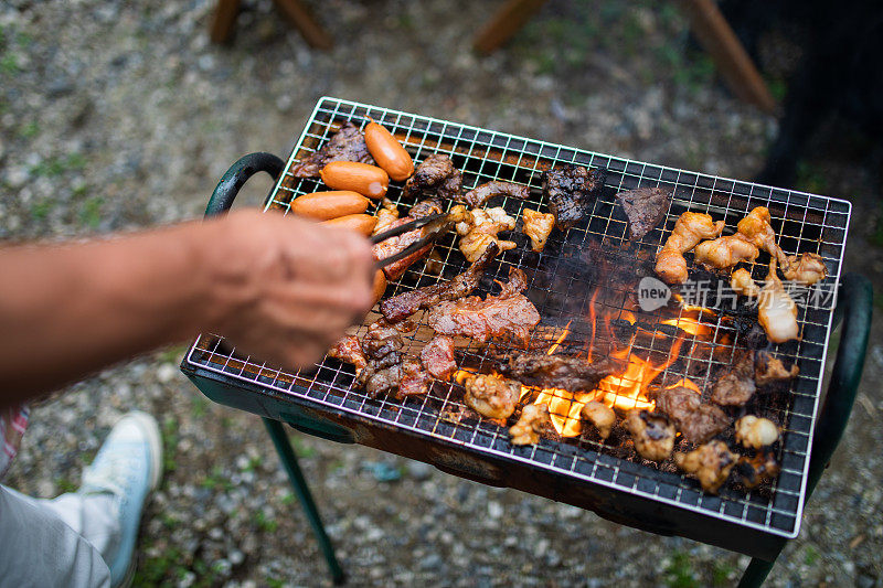 在外面用烤架烤一些肉吃午餐