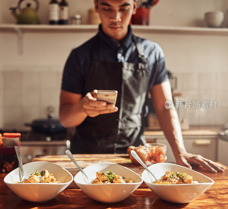 一名年轻男子用智能手机拍下自己在家准备的健康美食