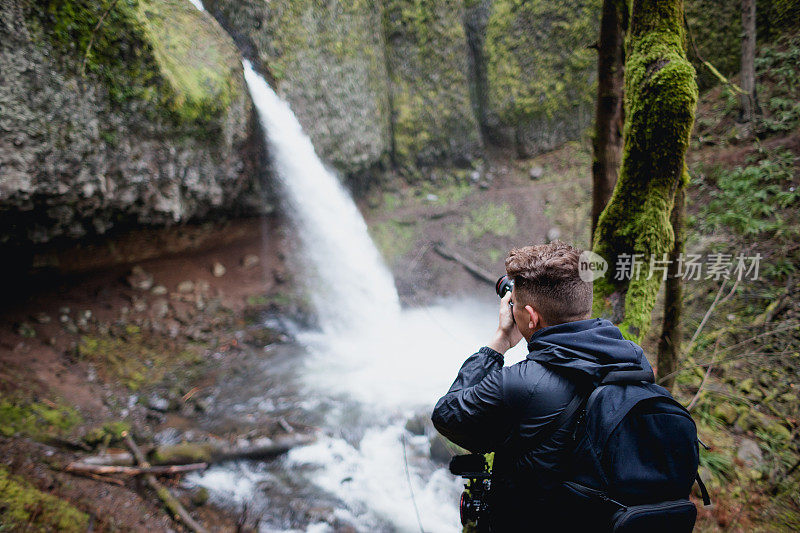 摄影师使用相机拍摄俄勒冈州瀑布的照片