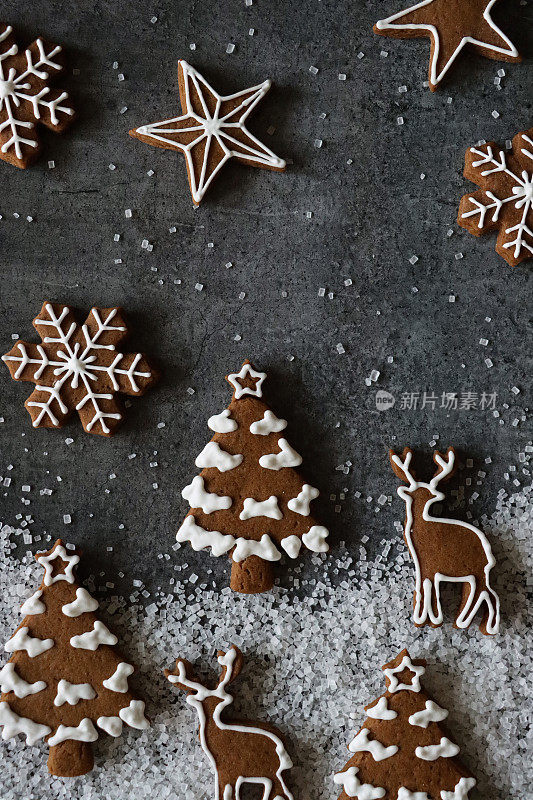 自制的形象，姜饼圣诞树饼干装饰白色皇家糖霜显示在白雪，圣诞森林场景，夜空星星和雪花饼干，黑色的背景，升高的视野