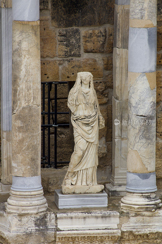 在Pamukkale的Hierapolis圆形剧场的两座大理石柱子之间的一个女人的雕像