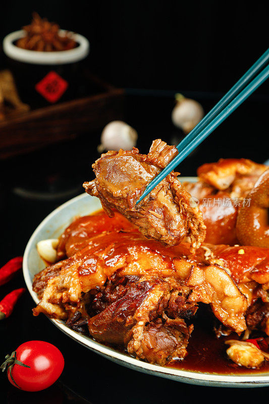 筷子上夹着卤味猪头肉