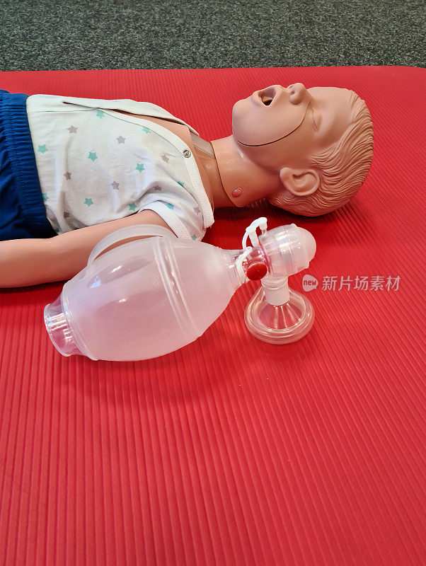 急救。关于儿童复苏的医疗简报。一个张着嘴的婴儿假人仰卧在一张红垫子上。医学专业的培养理念。