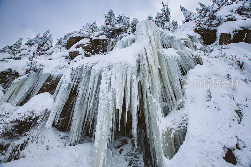 冰柱悬挂在积雪覆盖的山上的冬季景象