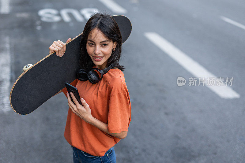 一个年轻的西班牙女人滑着滑板走在街上