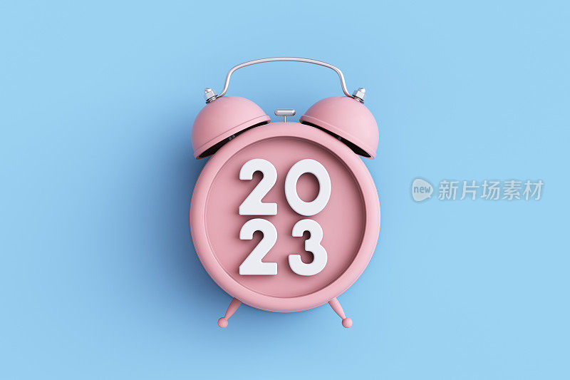 蓝色背景的粉色闹钟上显示2023