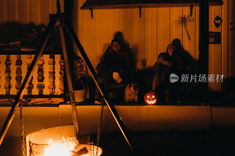 女人和男人的剪影在篝火旁享受万圣节的夜晚