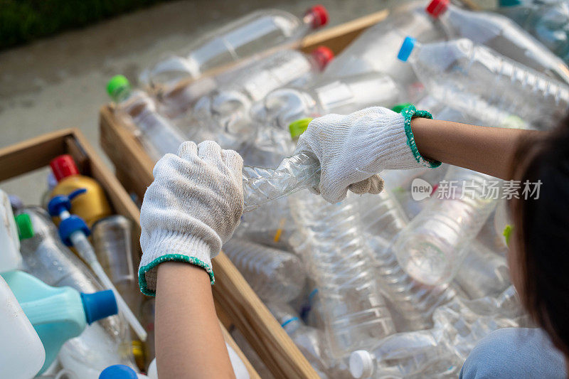 废物管理工人用工作手套拿着塑料瓶