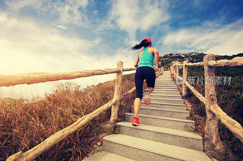 年轻的健身女性在山上的楼梯上跑步