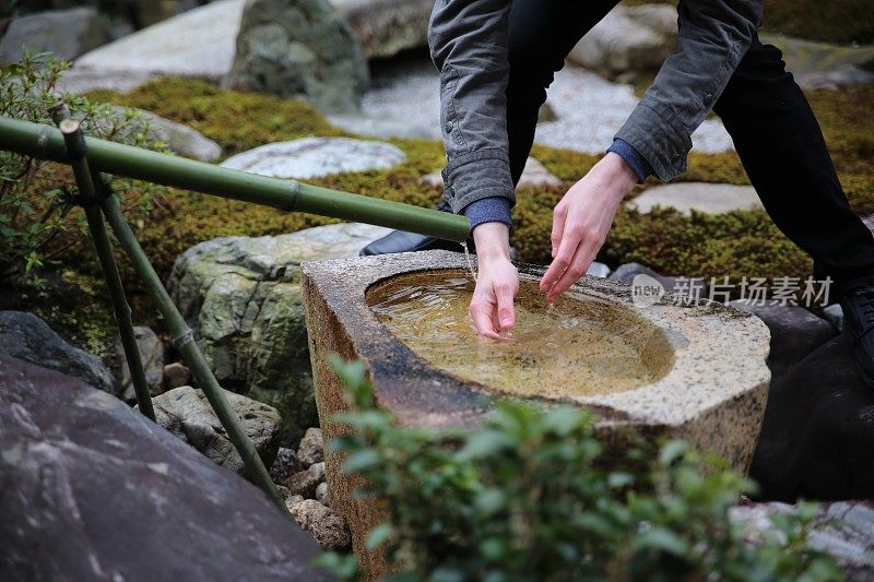 一对夫妇在日本寺庙花园洗手