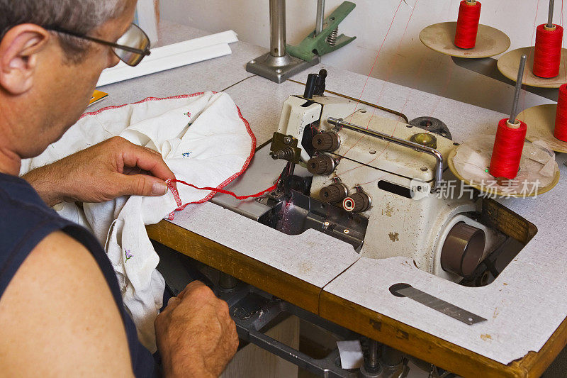 在他的工作室做裁缝……用缝纫机工作