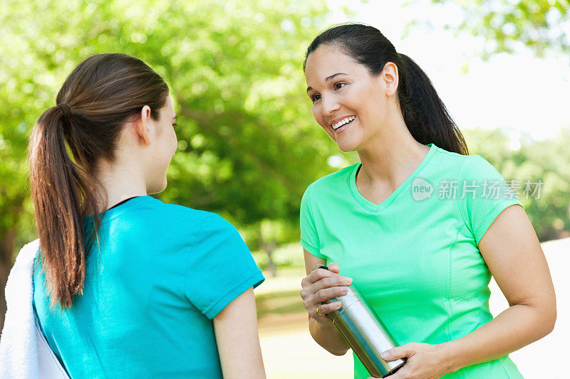 一个女人在健身后和一个十几岁的女孩聊天