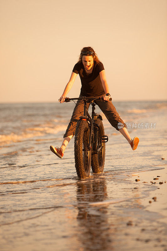 一个女人在海边骑着她的胖自行车