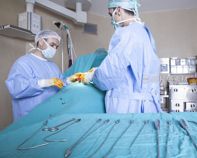 两名医生和男护士在手术室做手术