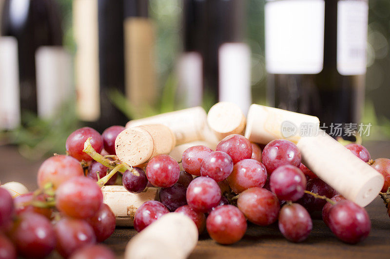 室外餐桌上的红葡萄和酒瓶。