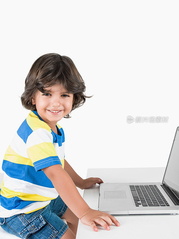 小男孩在用笔记本电脑