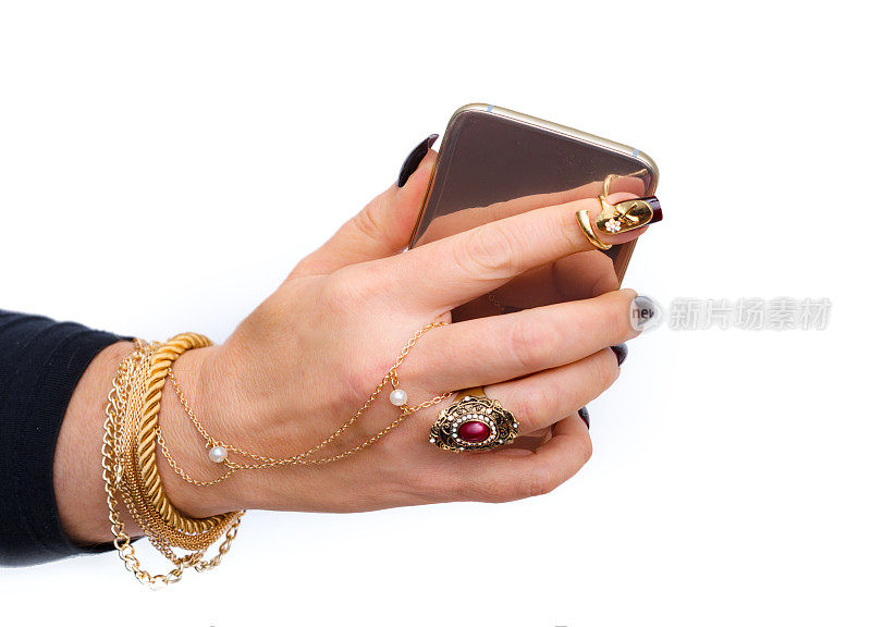 女性珠宝手与黑色指甲和金色智能手机