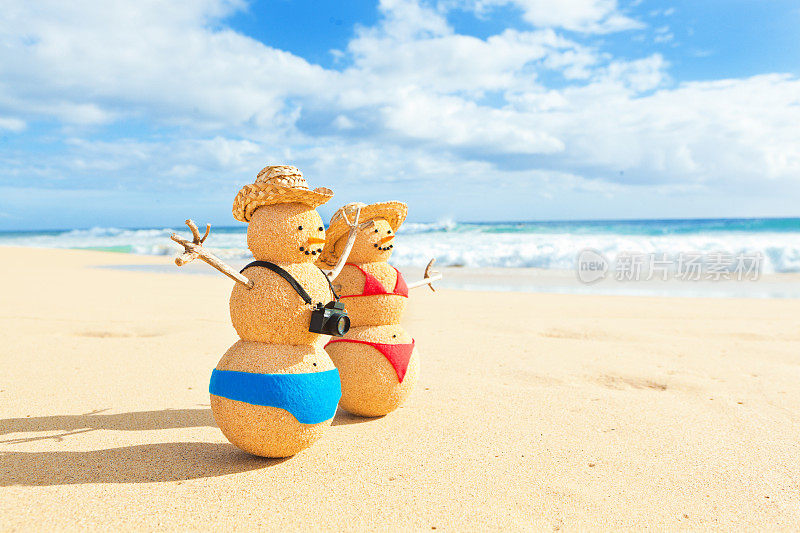 在热带海滩度假的沙雪人夫妇