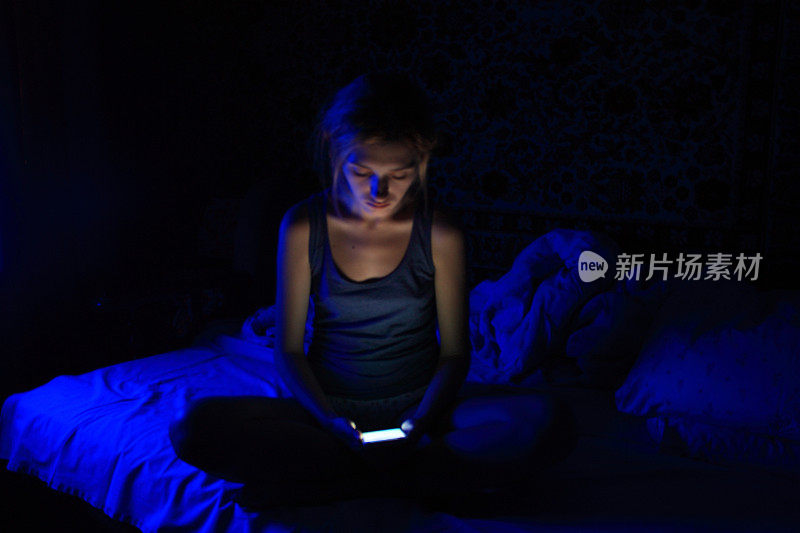 年轻女性在睡前使用智能手机