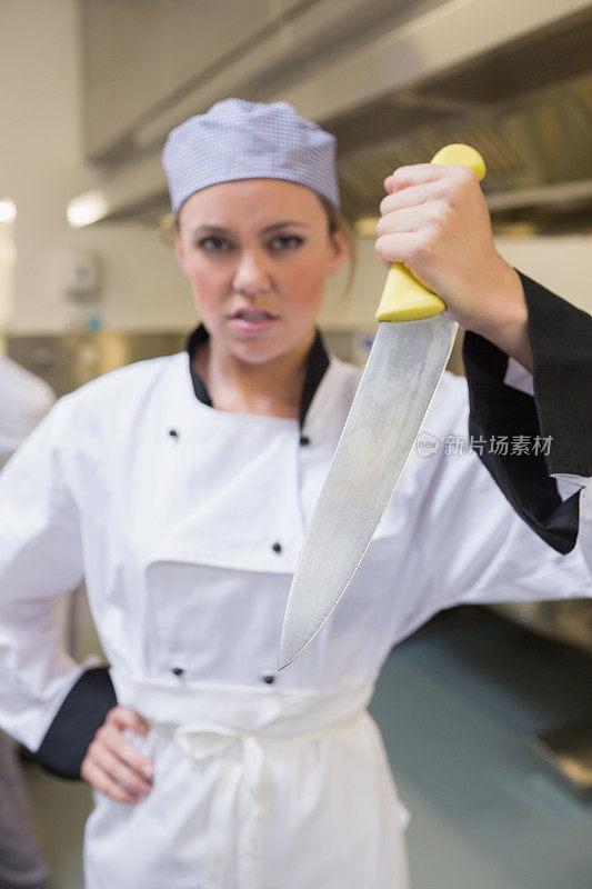 愤怒的女厨师拿着刀