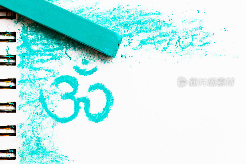 绿松石蜡笔粉笔在画板上的梵文Om符号