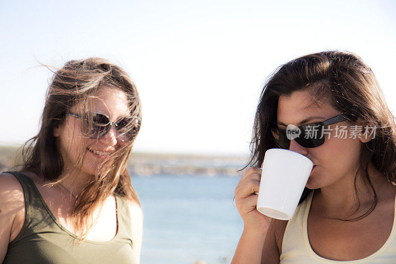 两个女人微笑着喝着咖啡