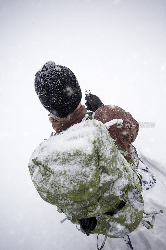 使用指南针的雪鞋背包客