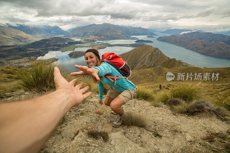 女登山队员伸出手向队友求助