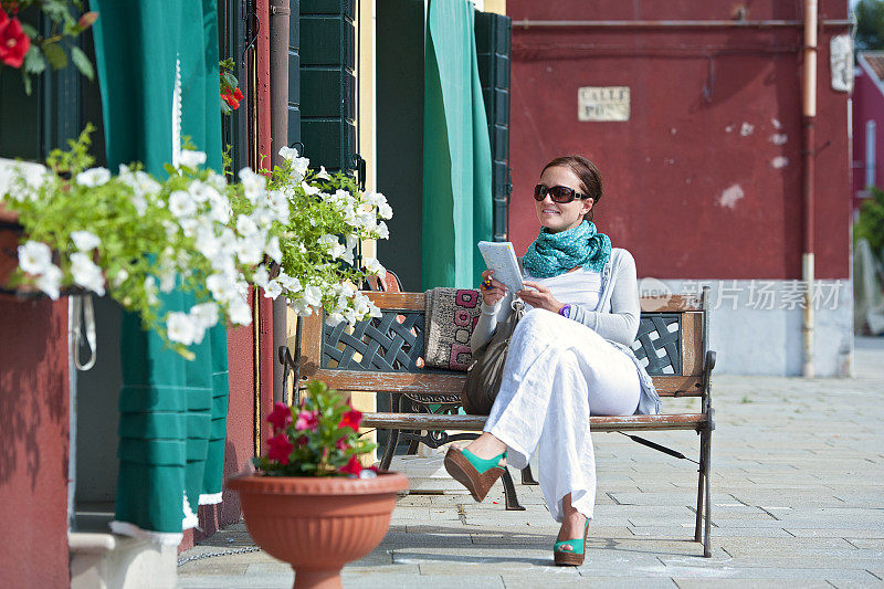 一个女人坐在长凳上看书
