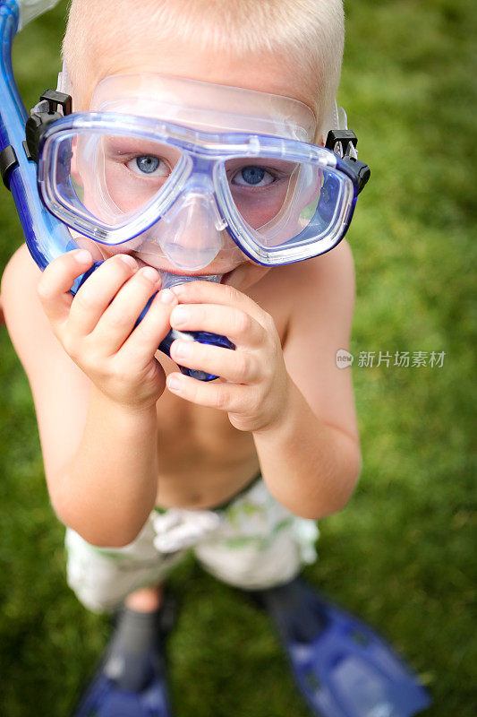 快乐的孩子带着通气管，面罩和脚蹼去游泳