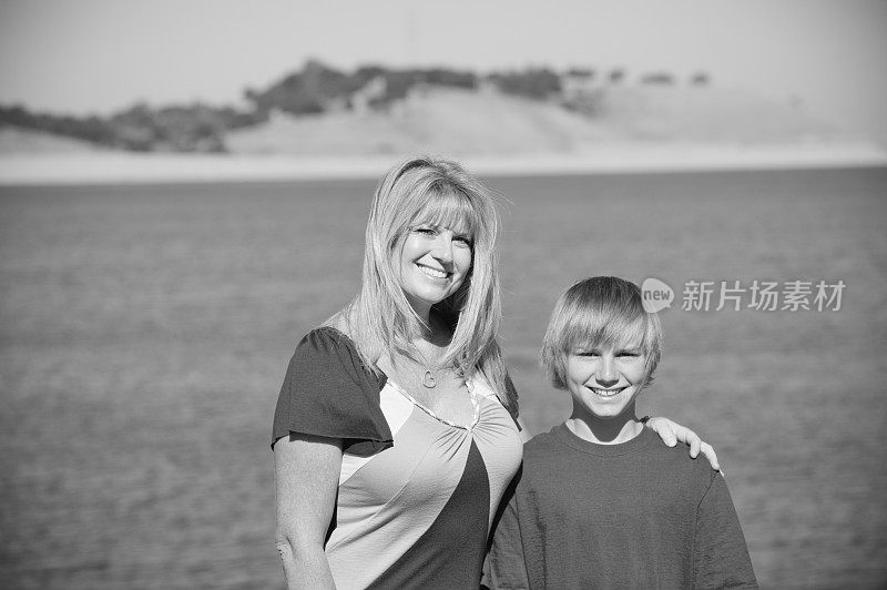 《黑人和白人母亲与儿子》在湖边。