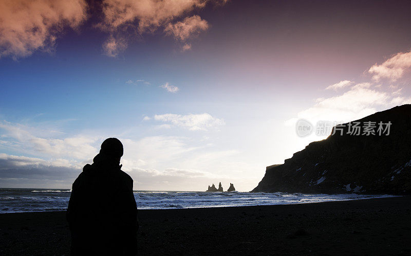 冰岛维克，一名男子的剪影看着雷尼斯德拉加海烟囱