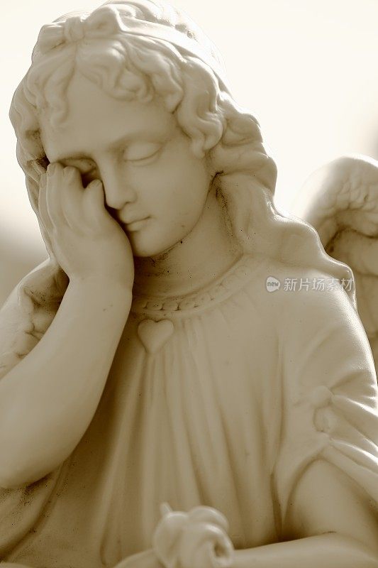 一个哭泣的天使在墓地的大理石雕像