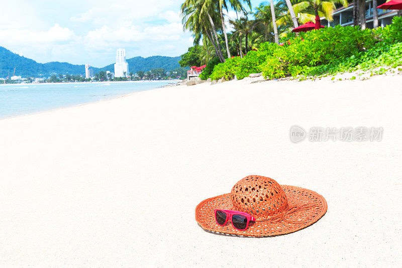 热带海滩上戴着太阳镜的太阳帽