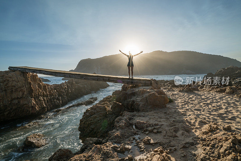 女人在海上向夕阳张开双臂