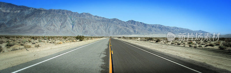 阳光明媚的夏日沙漠公路黄线全景图