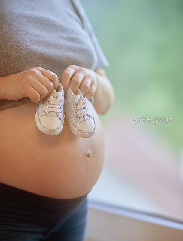 孕妇的肚子上穿婴儿鞋