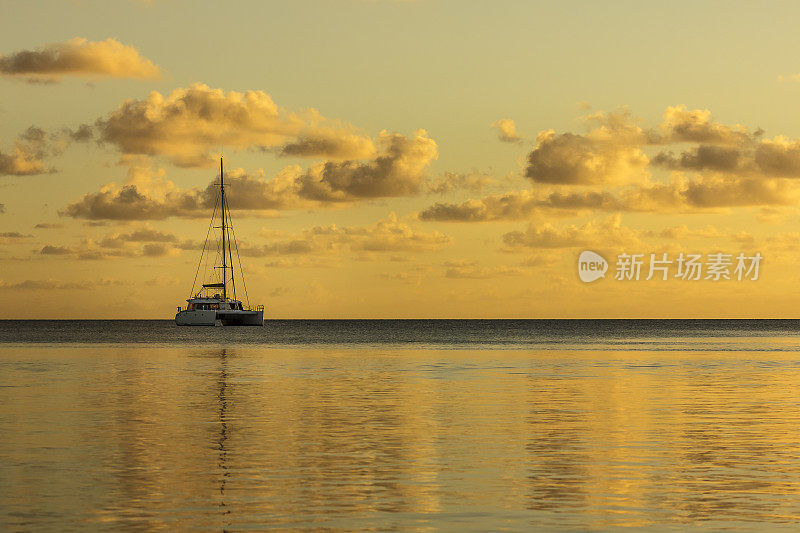 法属波利尼西亚兰伊罗的金色日落上的帆船