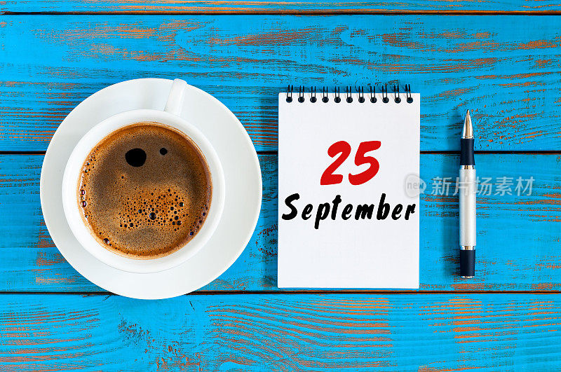 9月25日。每月25日，活页日历和卡布奇诺杯在行政工作背景。秋天的时间。文本空白