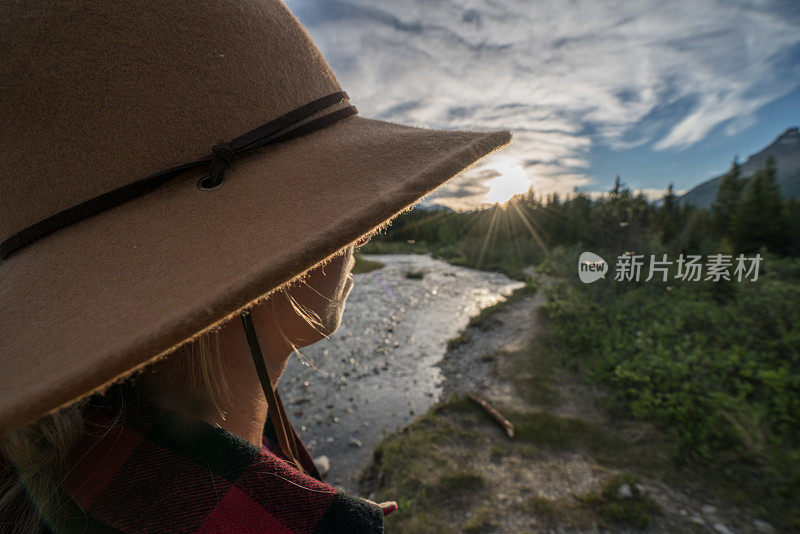 日落时分，女性在河边欣赏大自然