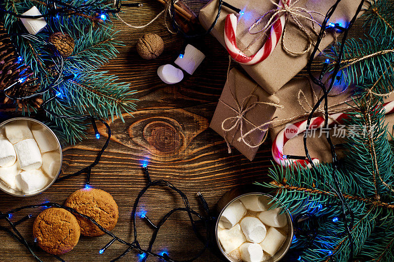 圣诞节喝。用马克杯热咖啡和棉花糖，红色拐杖糖在木制的背景。新的一年