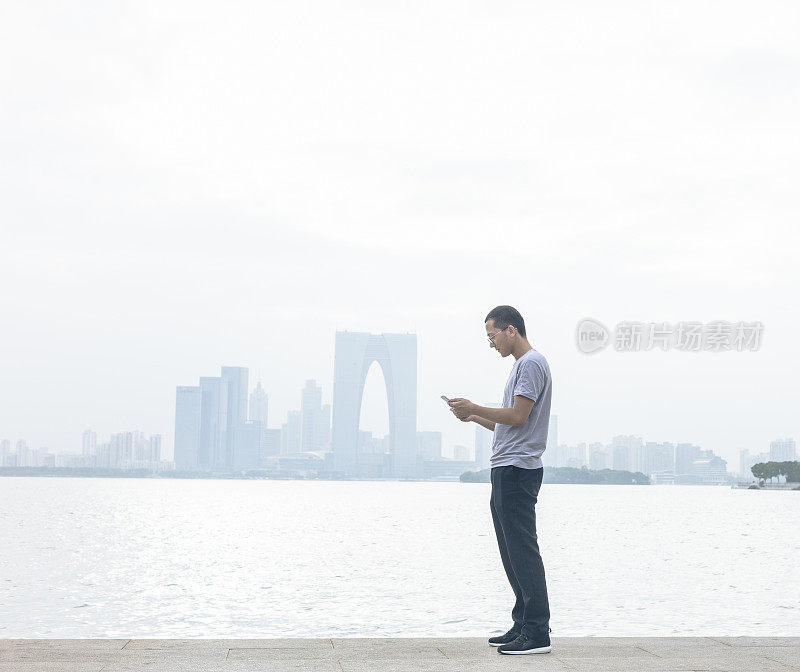 男子在金鸡湖边发短信
